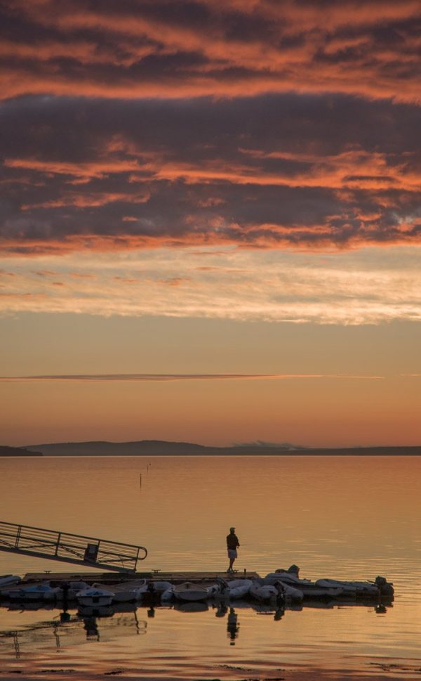 solitary fisherman on Bayside dock at dawn