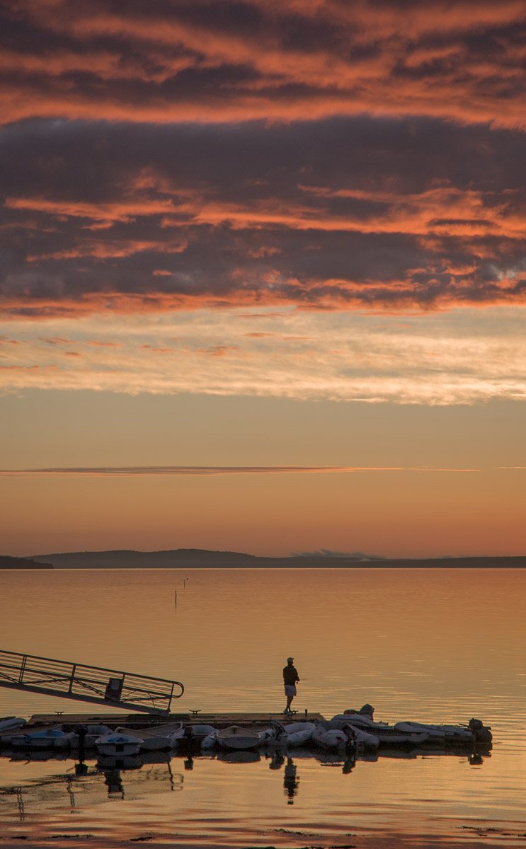 solitary fisherman on Bayside dock at dawn