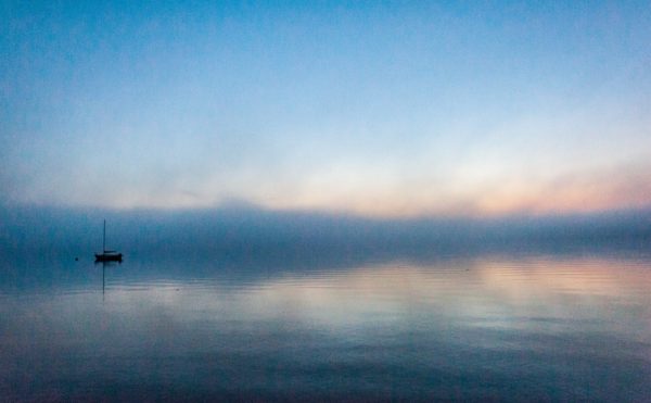 grainy image of solitary sailboat anchored in Bayside harbor, before sunrise