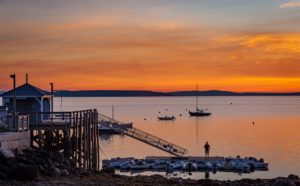 Solitary fisherman stands on the Bayside dock moments before sunrise