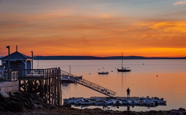 Solitary fisherman stands on the Bayside dock moments before sunrise