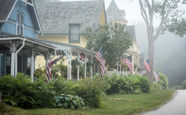 Row of summer cottages with American flags in foggy setting