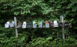 12 mailboxes lined up on a weathered support