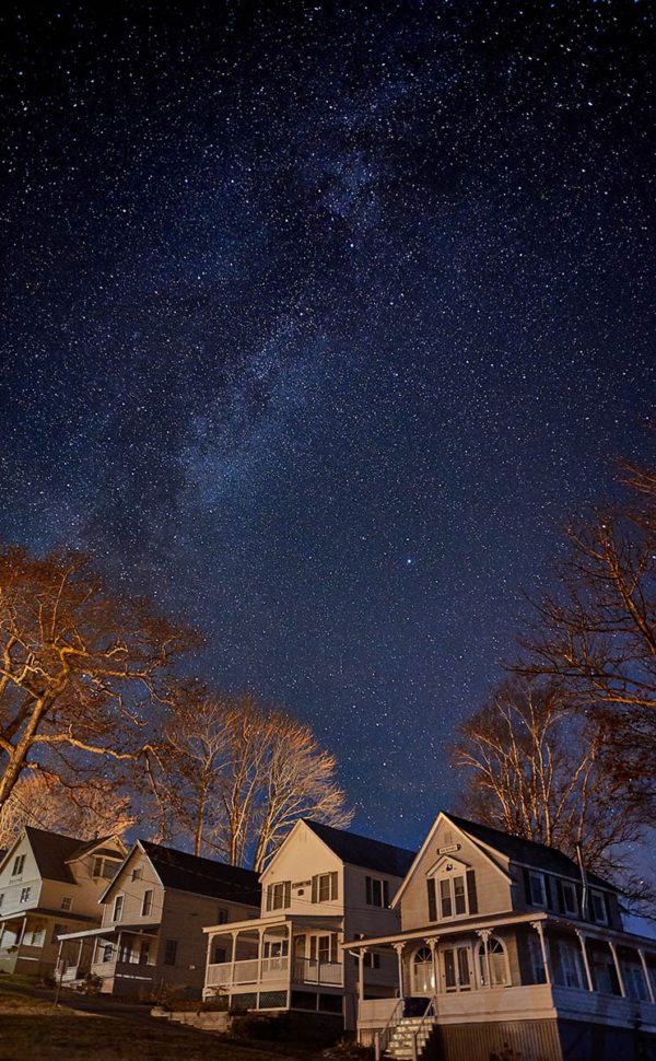 stars sweep over cottages on a clear night