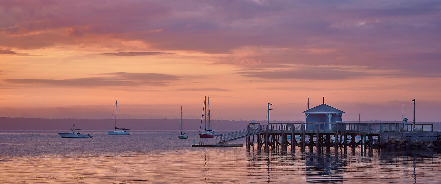 Bayside dock with colorful sunrise clouds